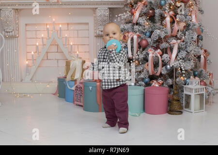 Bambino con un dono nelle mani nel nuovo anno di interni Foto Stock