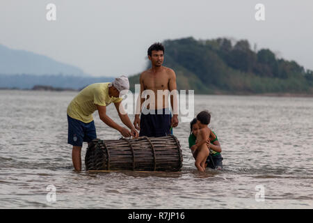 Don Daeng, Laos - Aprile 27, 2018: famiglia locale per la cattura di pesce al tramonto in una remota isola del fiume Mekong in Laos Foto Stock