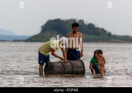 Don Daeng, Laos - Aprile 27, 2018: famiglia locale per la cattura di pesce al tramonto in una remota isola del fiume Mekong in Laos Foto Stock