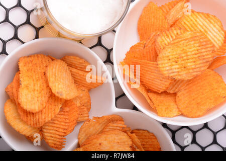 Bicchiere di birra con nachos chips su un sfondo astratto. Foto Stock