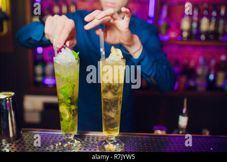 Barman mano spremendo il succo fresco di lime in vetro rendendo la Caipirinha Cocktail sul bancone del bar Foto Stock