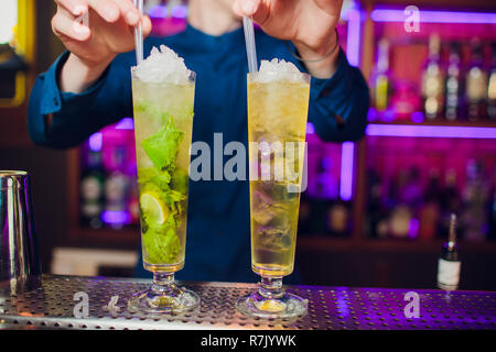 Barman mano spremendo il succo fresco di lime in vetro rendendo la Caipirinha Cocktail sul bancone del bar Foto Stock