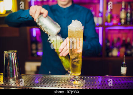 Barman mano spremendo il succo fresco di lime in vetro rendendo la Caipirinha Cocktail sul bancone del bar Foto Stock