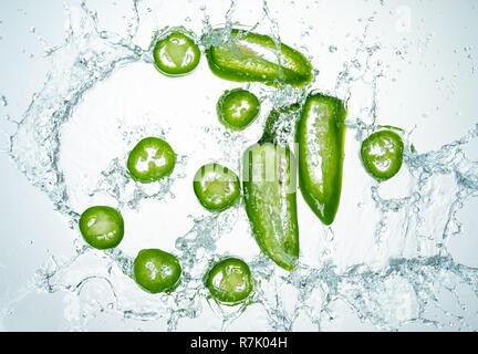 Congelare il movimento di peperoncini jalapeno con spruzzi di acqua Foto Stock