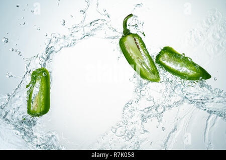 Congelare il movimento di peperoncini jalapeno con spruzzi di acqua Foto Stock