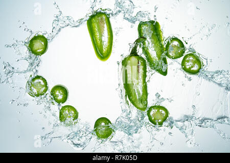 Congelare il movimento di peperoncini jalapeno con spruzzi di acqua Foto Stock