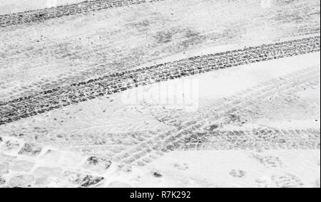 Sfocata città strada coperta con pneumatico neve tracce di pneumatici in inverno Foto Stock