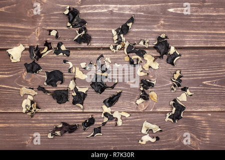 Sacco di fette di secco fungo nero ebreo orecchio varietà flatlay su legno marrone Foto Stock