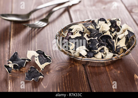 Sacco di fette di secco fungo nero ebreo orecchio varietà in ferro vecchio ciotola di legno marrone Foto Stock