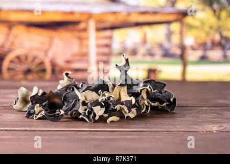 Sacco di fette di secco fungo nero ebreo orecchio varietà con carrello in background Foto Stock