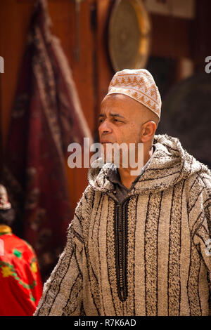 Il Marocco, Fes, Fes el Bali, Medina, uomo indossando il tradizionale tessuto a mano Djellaba cappotto con cappuccio, Foto Stock