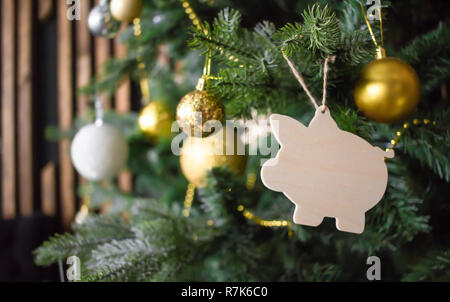 Giocattolo di suino l'albero di Natale. Palline dorate, perline, altre decorazioni. Anno nuovo concetto di simbolo. Foto Stock
