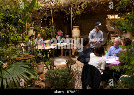 Il Marocco, Fes, Fes el Bali, Medina, rovinato ristorante con giardino i clienti su tavoli all'aperto Foto Stock