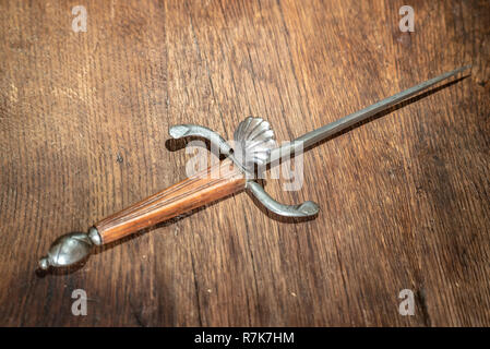 Pugnale antico e vecchio su sfondo di legno Foto Stock