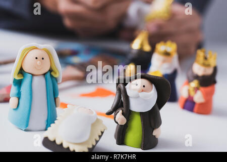 Un uomo caucasico dipinto a mano diverse figurine di un presepe Foto Stock