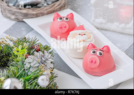 Il marzapane a forma del simbolo del nuovo anno rosa - un suino, dolce e delicato amaretti, marshmallows, arachidi zucchero in colori pastello su una luce ba Foto Stock