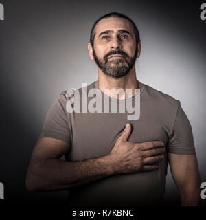 L'uomo con la mano sul suo cuore studio shot Foto Stock