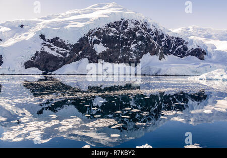 Montagna innevata e il ghiacciaio riflessa nelle acque antartiche di baia Neko, Antartide Foto Stock