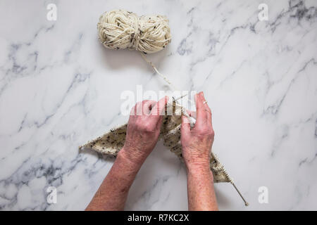 Senoir donna con le mani in mano la tessitura di un ponticello. Vista aerea. Foto Stock