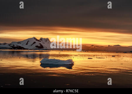 Tramonto sulla laguna con vaganti iceberg e neve montagne sullo sfondo, Lemaire Channel, Antartide Foto Stock