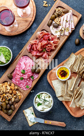 Antipasto Platter. Prosciutto Serrano, salame jamon olive Salse dip e vino rosso Foto Stock
