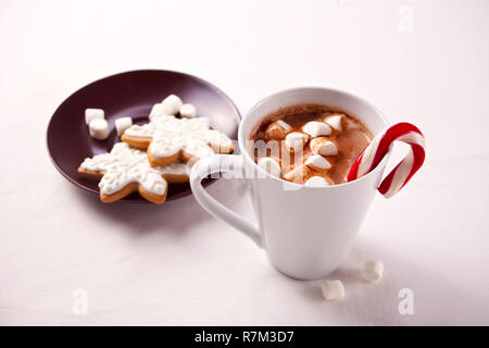 Natale con cacao marshmallows, candy cane, cookie e altre decorazioni su sfondo bianco Foto Stock