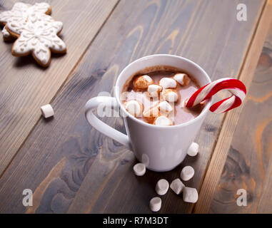 Natale con cacao marshmallows, candy cane e i cookie di fiocchi di neve sul tavolo di legno Foto Stock