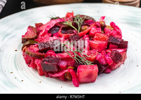 Insalata di barbabietole. Condimento è un tradizionale insalata russa fatta da bietole e verdure. Tre coppe con insalata. Foto Stock