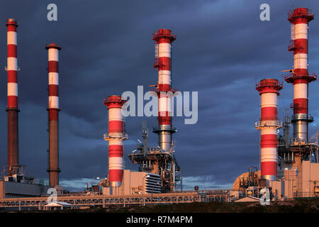 Parte di una grande raffineria di petrolio e powerplant al crepuscolo contro un cielo nuvoloso prima pioggia Foto Stock