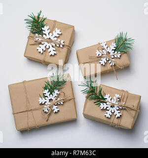 Regali di natale con rami di abete e fiocchi di neve in legno su sfondo bianco, Vacanze invernali Concept Foto Stock