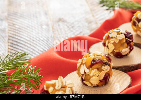 Fatti a mano le sfere di energia sono giacenti su legno sezionature sulla stoffa rossa su un tavolo di legno. Foto Stock