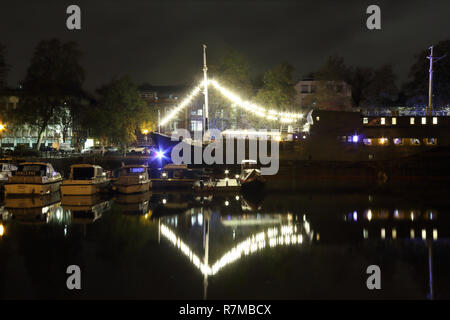 Una grande barca a vela con fata luci e decorazioni che riflettono sul fiume Avon nell'isola di Spike wharf, di notte, Regno Unito Foto Stock