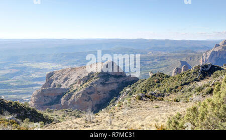 Un paesaggio del pre-Pirenei terre, con rocce e di abete e pino foreste nell'Mallos de Riglos picchi di montagna durante il periodo invernale in Aragona, Spagna Foto Stock