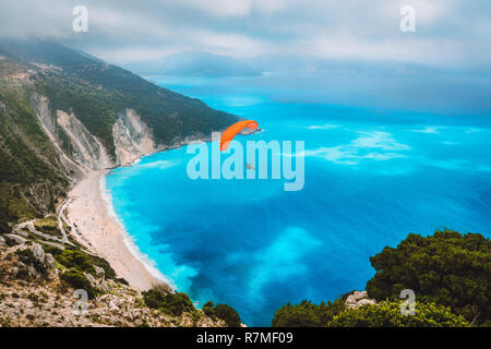 Vista aerea del parapendio volando sopra la splendida spiaggia di Myrtos. Acqua di incredibili colori e bellissimo litorale sull'isola di Cefalonia, Grecia Foto Stock