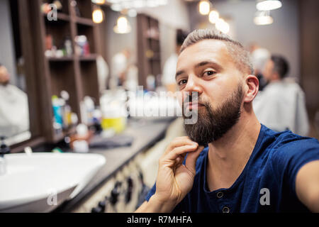 Hipster uomo client haidresser visita e un parrucchiere in un barbiere. Foto Stock