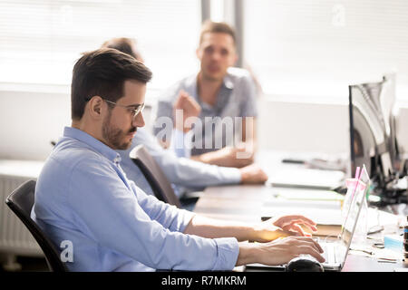Imprenditore gravi utilizzando computer portatile al posto di lavoro che stanno guardando sullo schermo Foto Stock