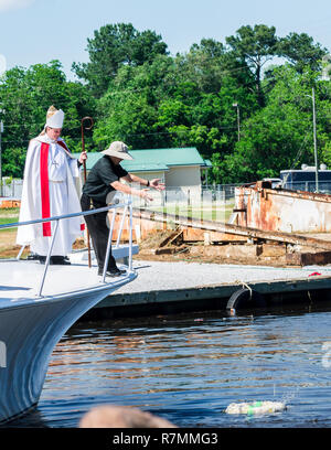 Il rev. Nguyen Bieu lancia una corona in bayou alla benedizione della flotta come l Arcivescovo Thomas J. Rodi orologi in Bayou La Batre, Alabama. Foto Stock