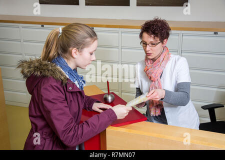 La pratica medica, la receptionist consegna un rinvio a uno specialista per un paziente, Germania Foto Stock