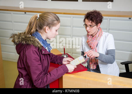 La pratica medica, la receptionist consegna un rinvio a uno specialista per un paziente, Germania Foto Stock