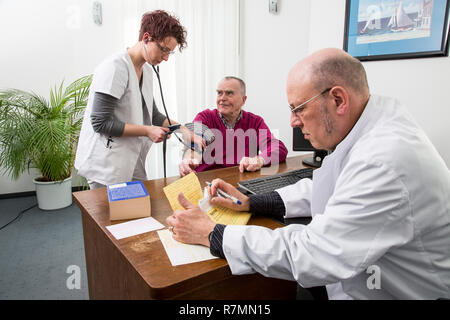 Ambulatorio medico, pazienti anziani ottiene la sua pressione del sangue preso da un medico assistente, Germania Foto Stock