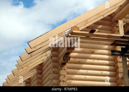 Processo di casa in legno dritto pendenza del tetto montaggio vista anteriore. Paese di legno Costruzione casa Foto Stock
