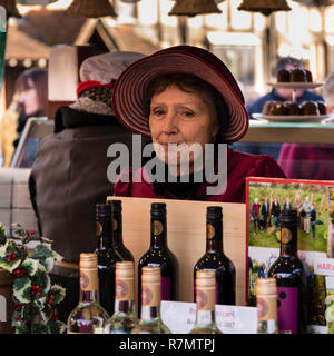 Signora stallholder vendita di vino in costume tradizionale al Victorian Mercatino di Natale, Stratford upon Avon Foto Stock