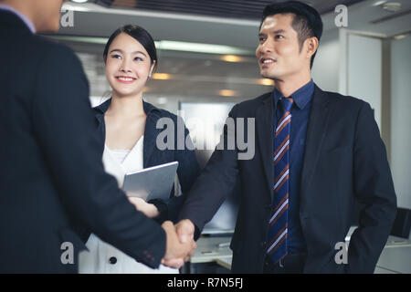 La gente di affari si stringono la mano e sorridendo il loro accordo per firmare il contratto e la finitura di una riunione Foto Stock