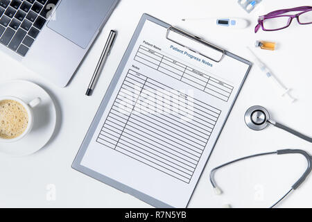 Il decorso del paziente nota con uno stetoscopio e accessori per medico sul tavolo bianco, Health care concept Foto Stock