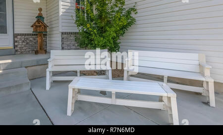 Casa con mobili in legno bianco sul patio anteriore Foto Stock