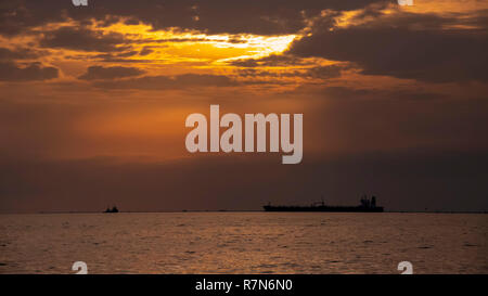 Colorato Cielo di tramonto tra le nuvole sul mare con sagome di navi. La Grecia Foto Stock