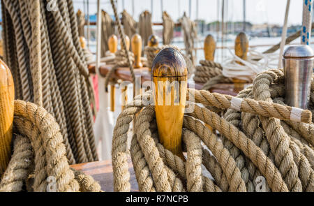 Close-up di corde in dotazione sul ponte di una barca a vela. Dettaglio dei tasselli di legno con la Nautica Corde ormeggiate. Foto Stock