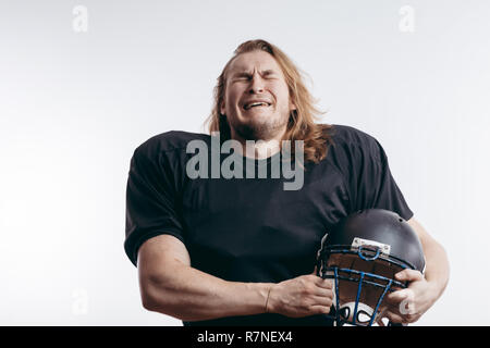 Rugby Football player nella disperazione, l'uomo con i capelli lunghi su sfondo isolato Foto Stock