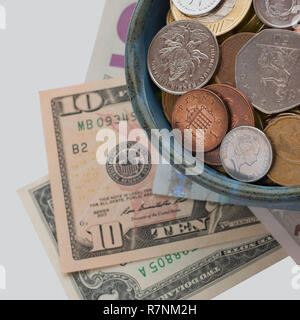Le monete e le banconote provenienti da diversi paesi. Tazza di abbondanza, simbolo di ricchezza e di abbondanza. Concetto del tesoro. Immagine quadrata Foto Stock