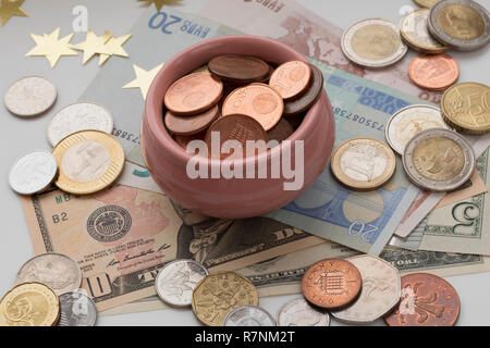 Tazza di abbondanza, simbolo di ricchezza e di abbondanza. Concetto del tesoro. Le monete e le banconote provenienti da diversi paesi. Foto Stock